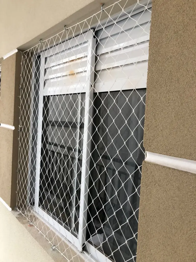 Rede de proteção instalada em janela com persiana